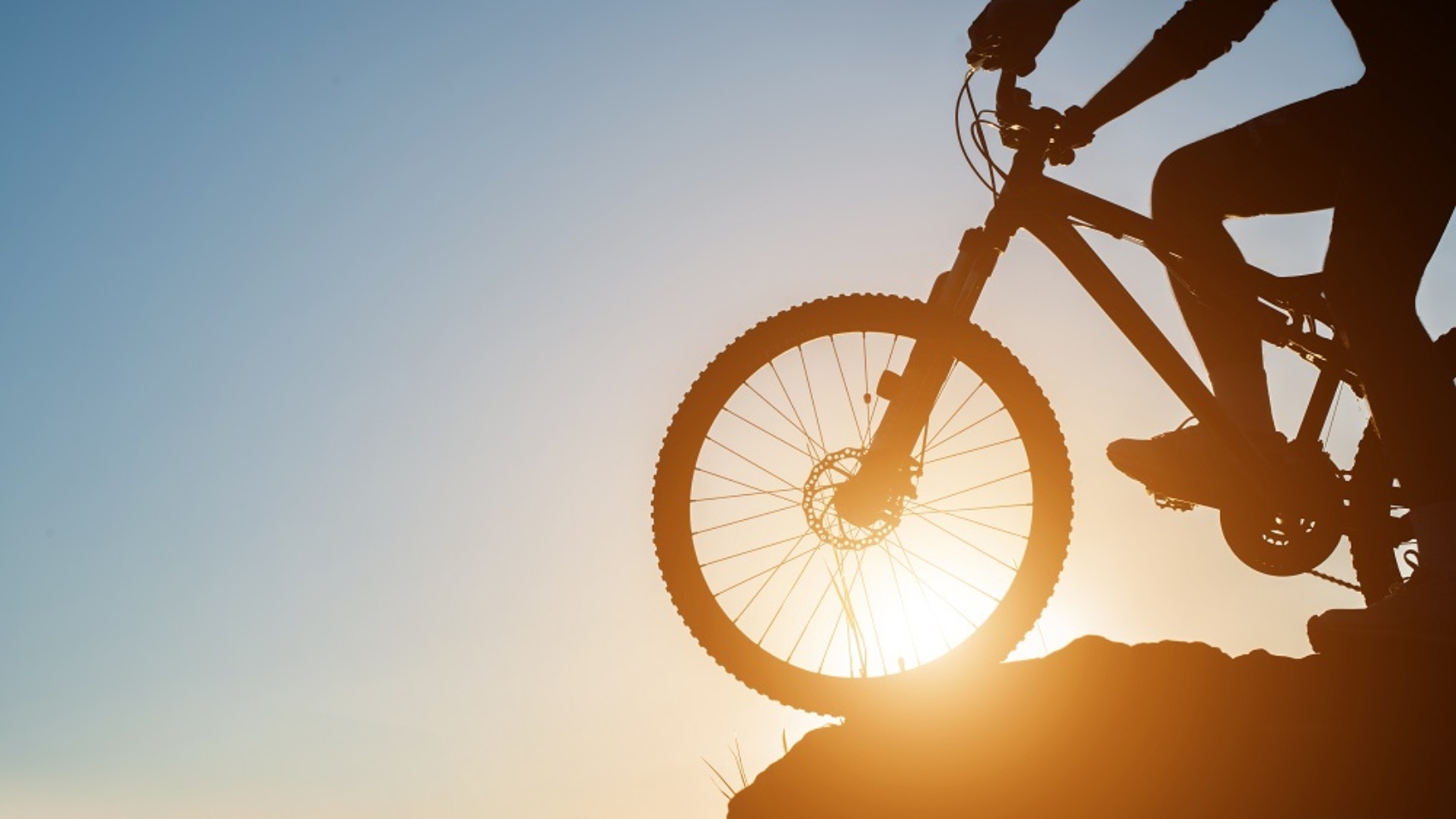 Silhouette of a man on mountain-bike during sunset.