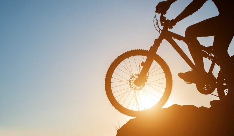 Silhouette of a man on mountain-bike during sunset.